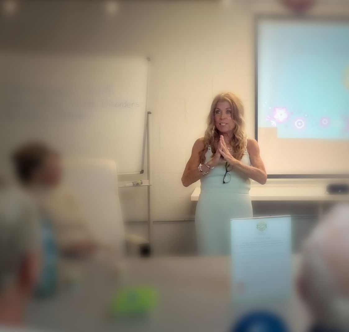 A woman is giving a presentation in front of a group of people