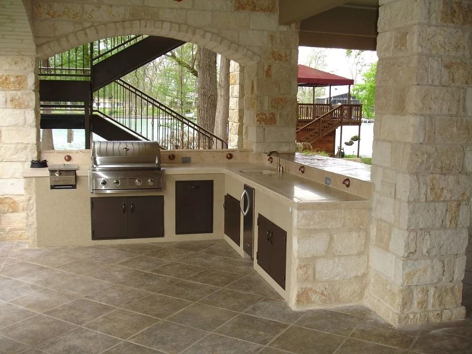 A kitchen with a grill and stairs in the background