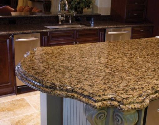 A kitchen with a large granite counter top and a sink.