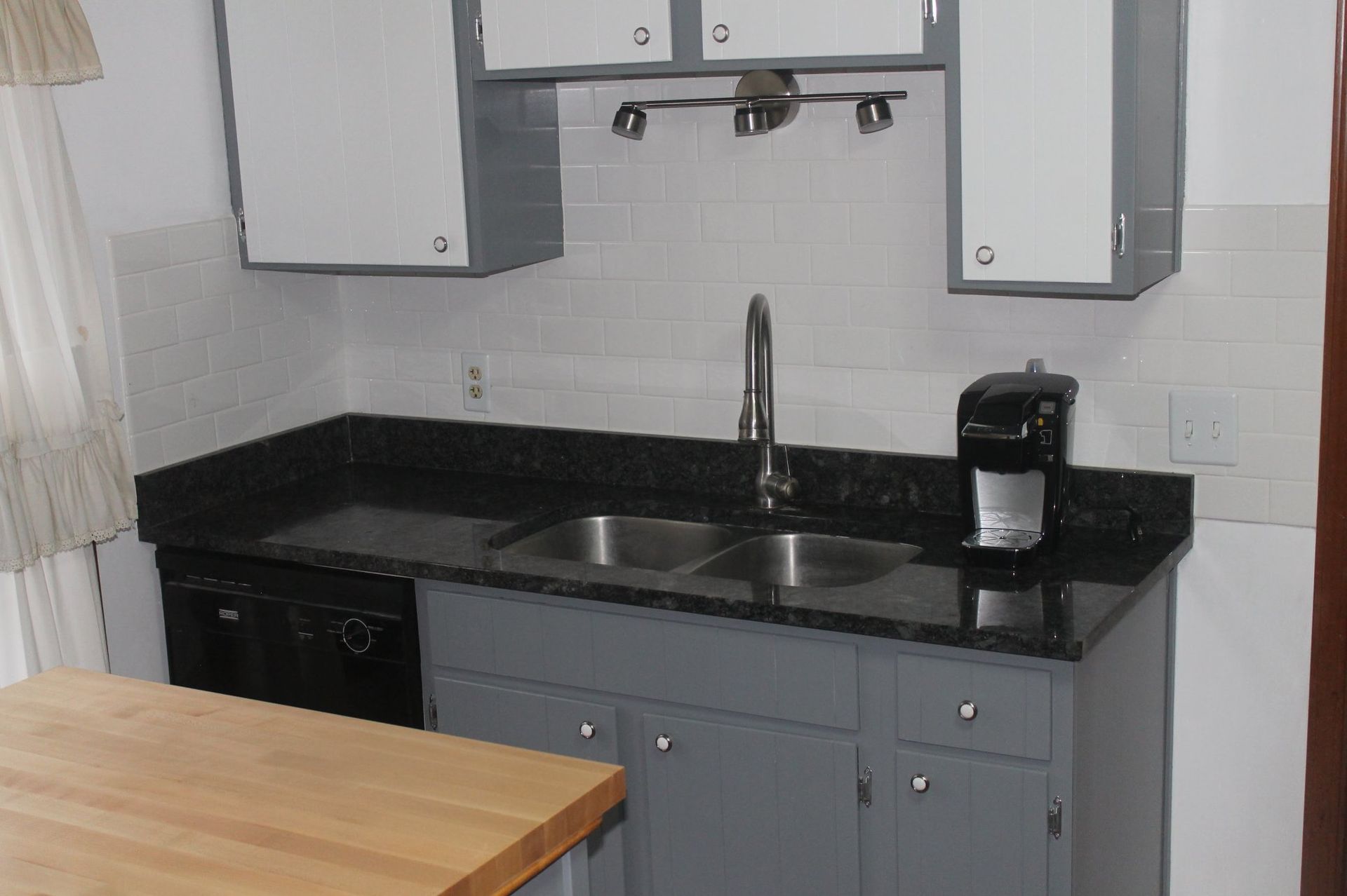 A kitchen with two sinks and a coffee maker