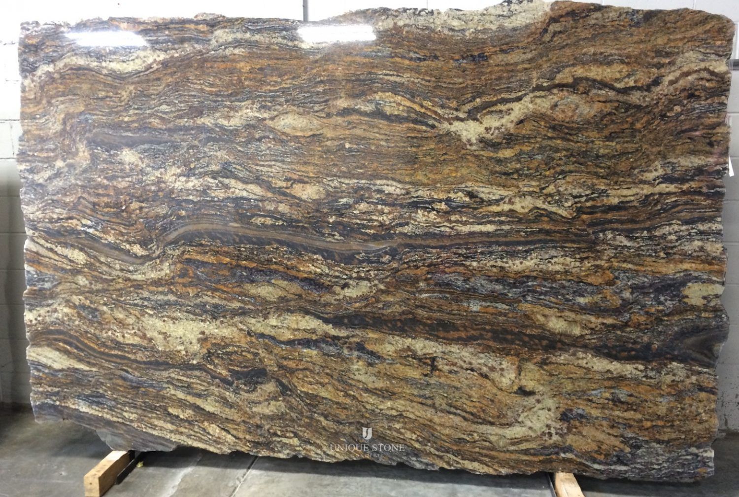 A large slab of granite is sitting on a wooden stand.