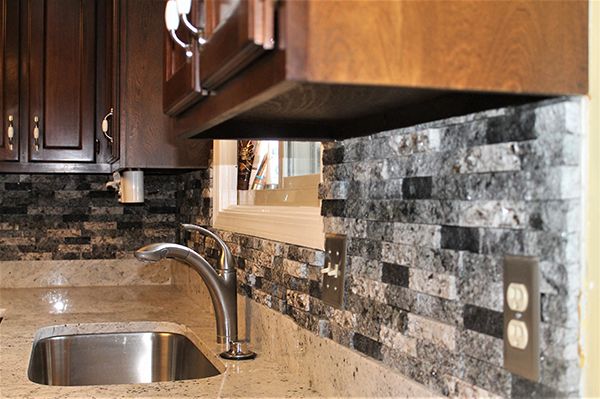 A kitchen with a stainless steel sink and a faucet