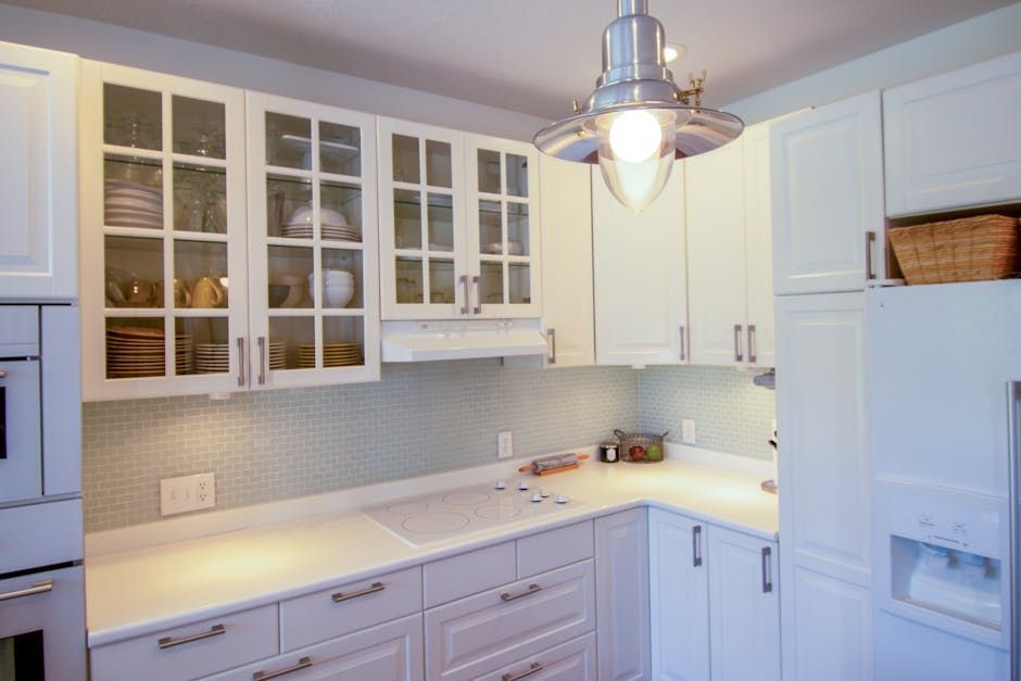 A kitchen with white cabinets and white counter tops