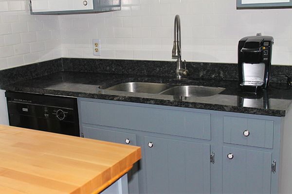 A kitchen with two sinks and a coffee maker
