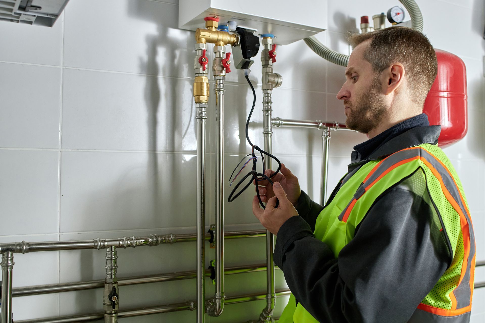 HVAC technician inspecting or repairing a heating unit in a house.