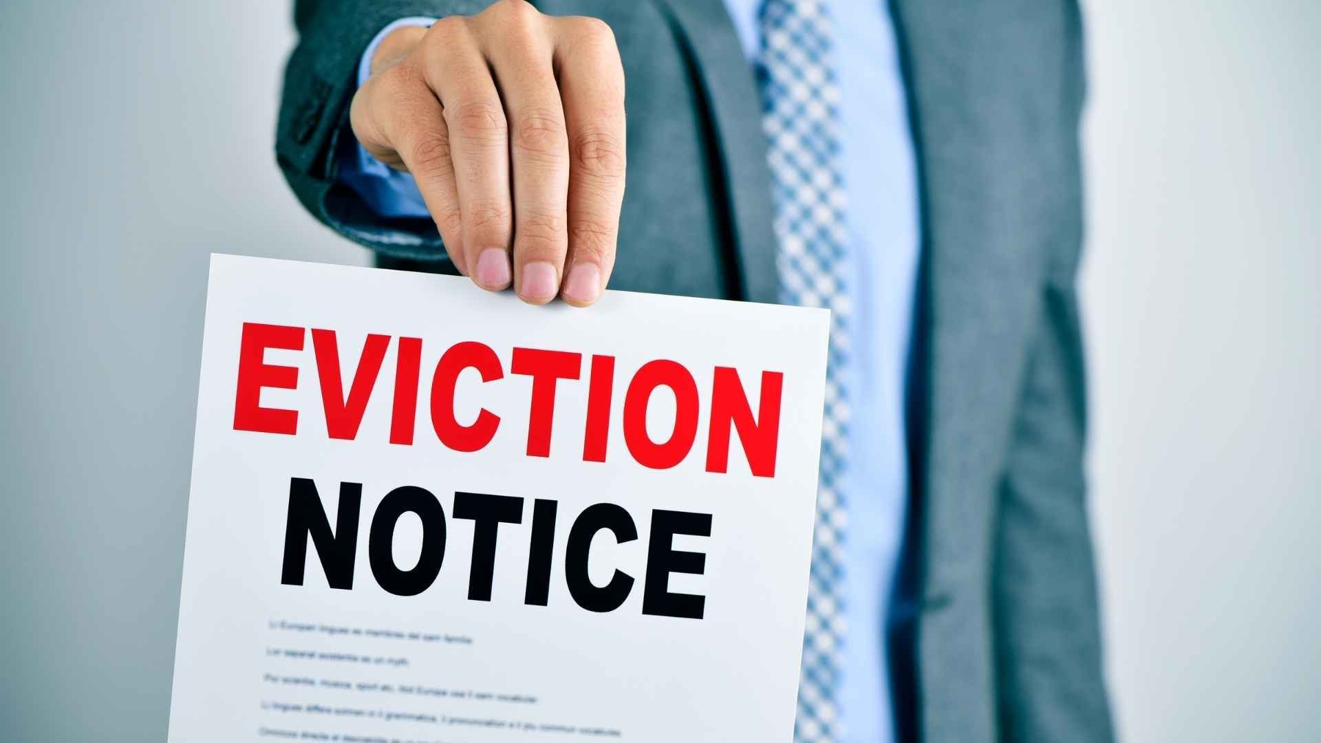 a person holding up an eviction notice