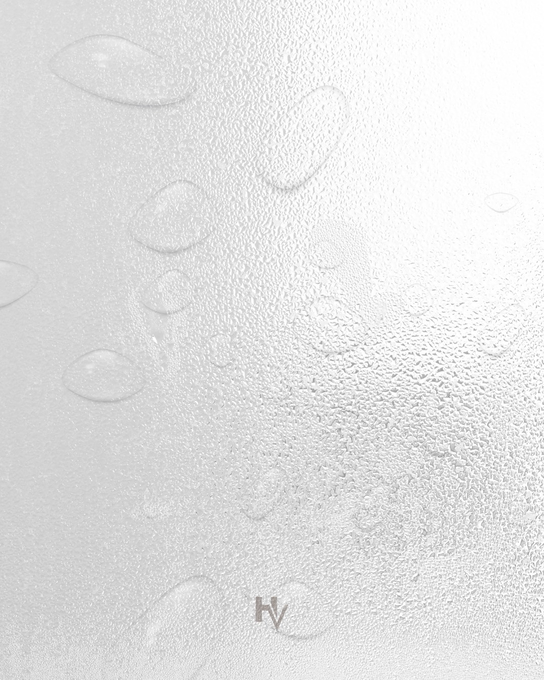 Water droplets on a textured white surface. The letters 