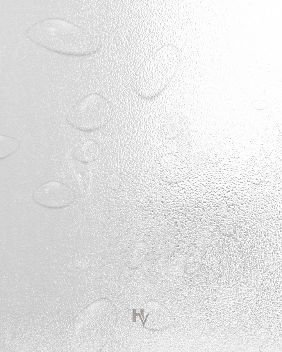 Close-up of a textured, wet white surface with water droplets and the letters