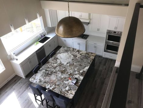 An aerial view of a kitchen with a large granite counter top.