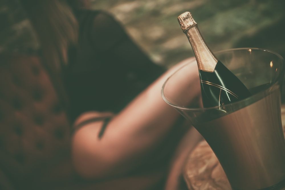 Champagne Bottle in a Bucket, With a Person in a Dark Top Resting Nearby — BYO Cellars in Grafton, NSW