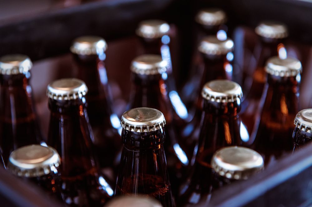 Brown Beer Bottles in a Crate, Silver Bottle Caps, Close-up Shot — BYO Cellars in Lismore, NSW
