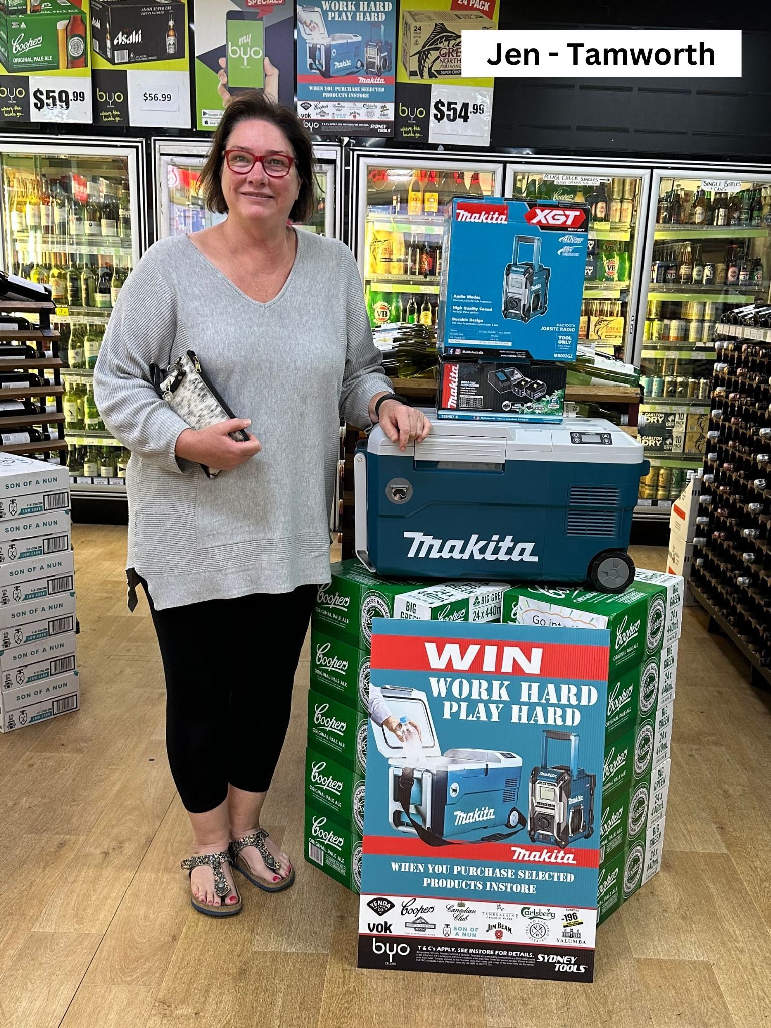 Woman stands next to Makita prize display at store, holding a clutch. Text reads: