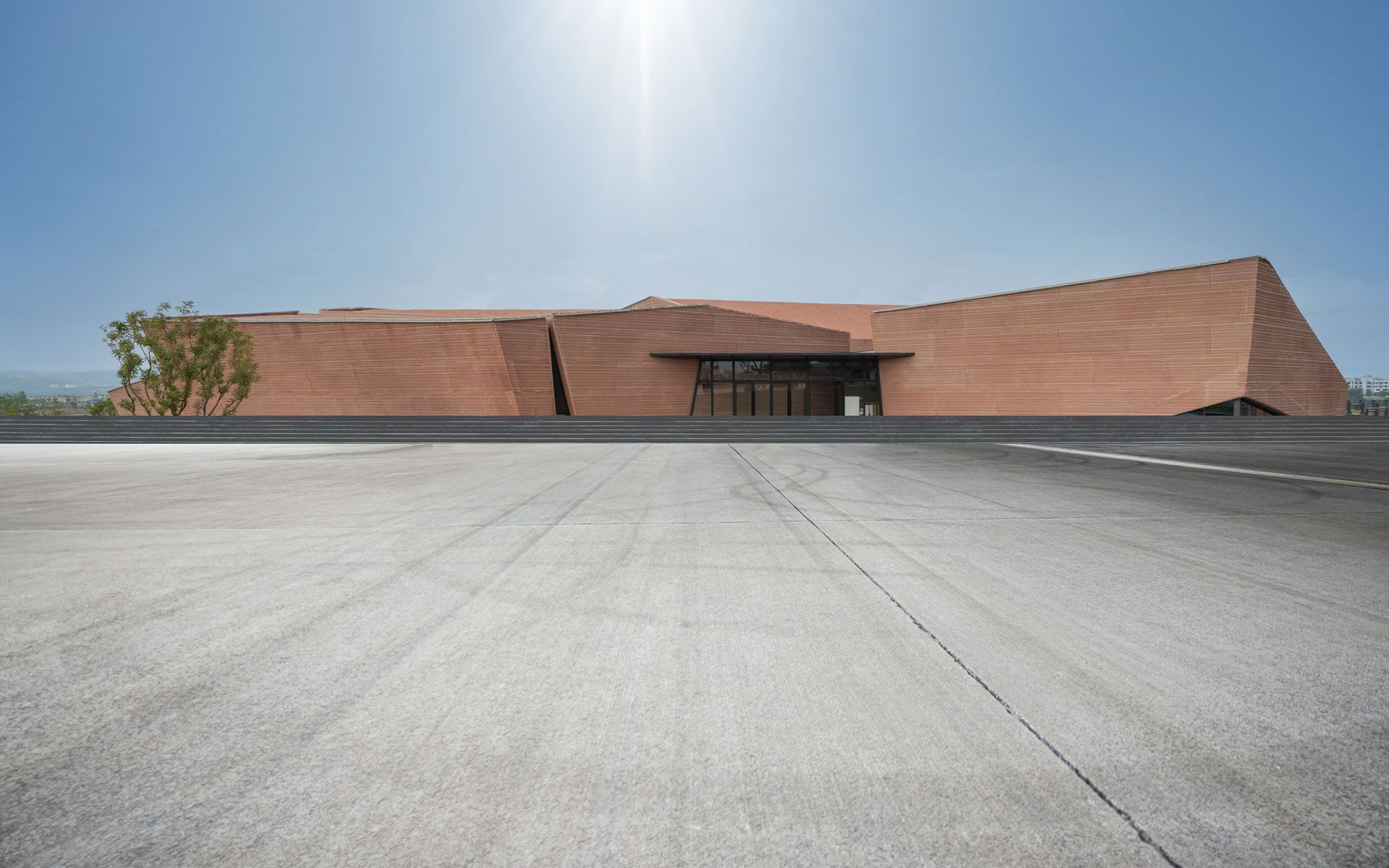 An empty parking lot in front of a large brick building.