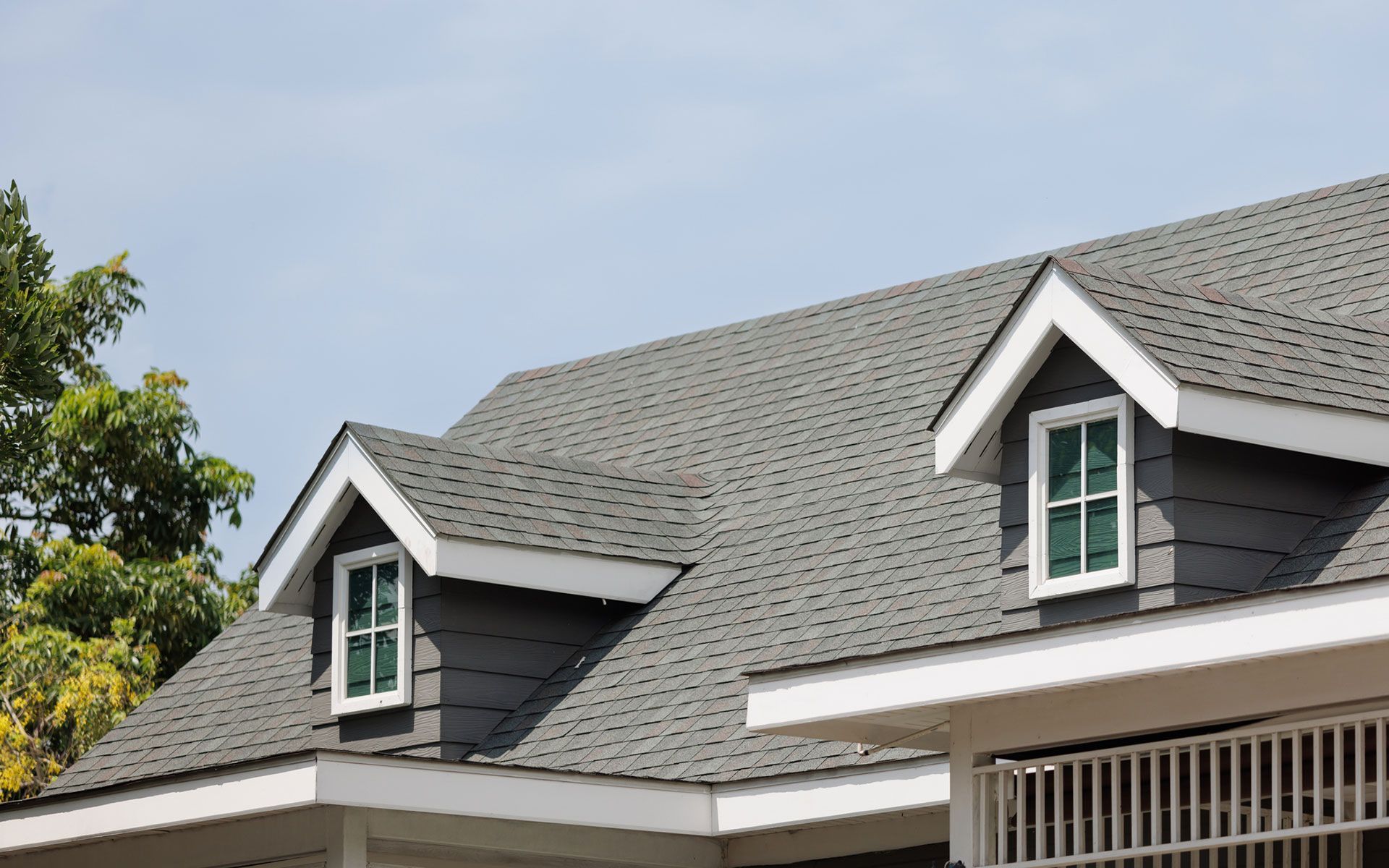 The roof of a house with two windows on it.