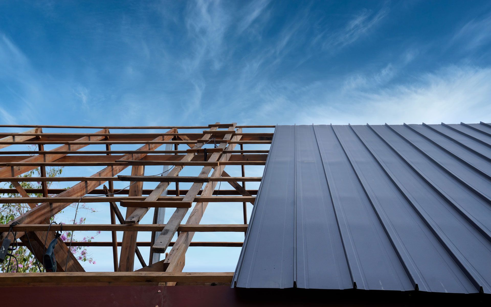 A metal roof is being installed on a house under construction.