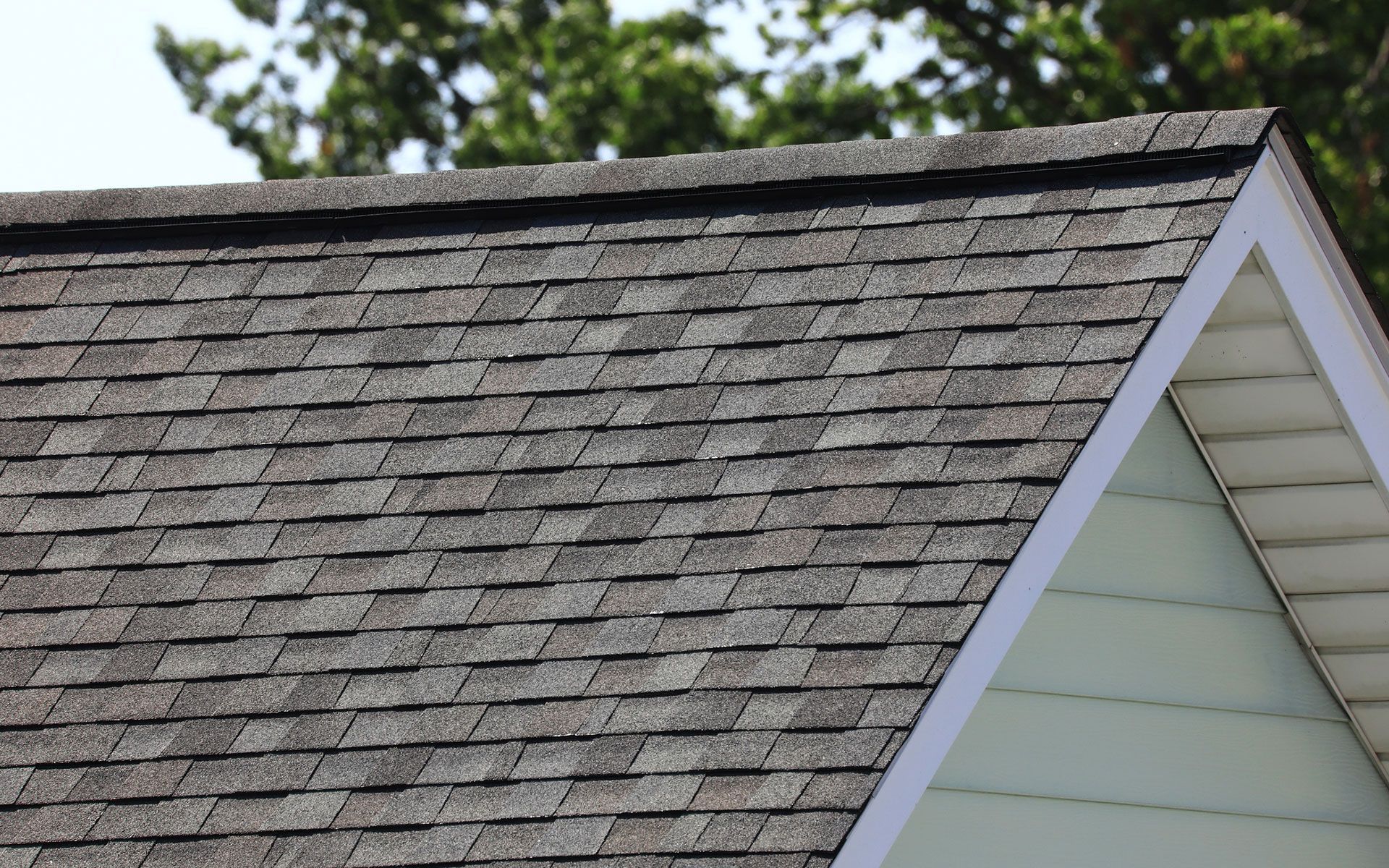 A close up of a roof with shingles on a house.