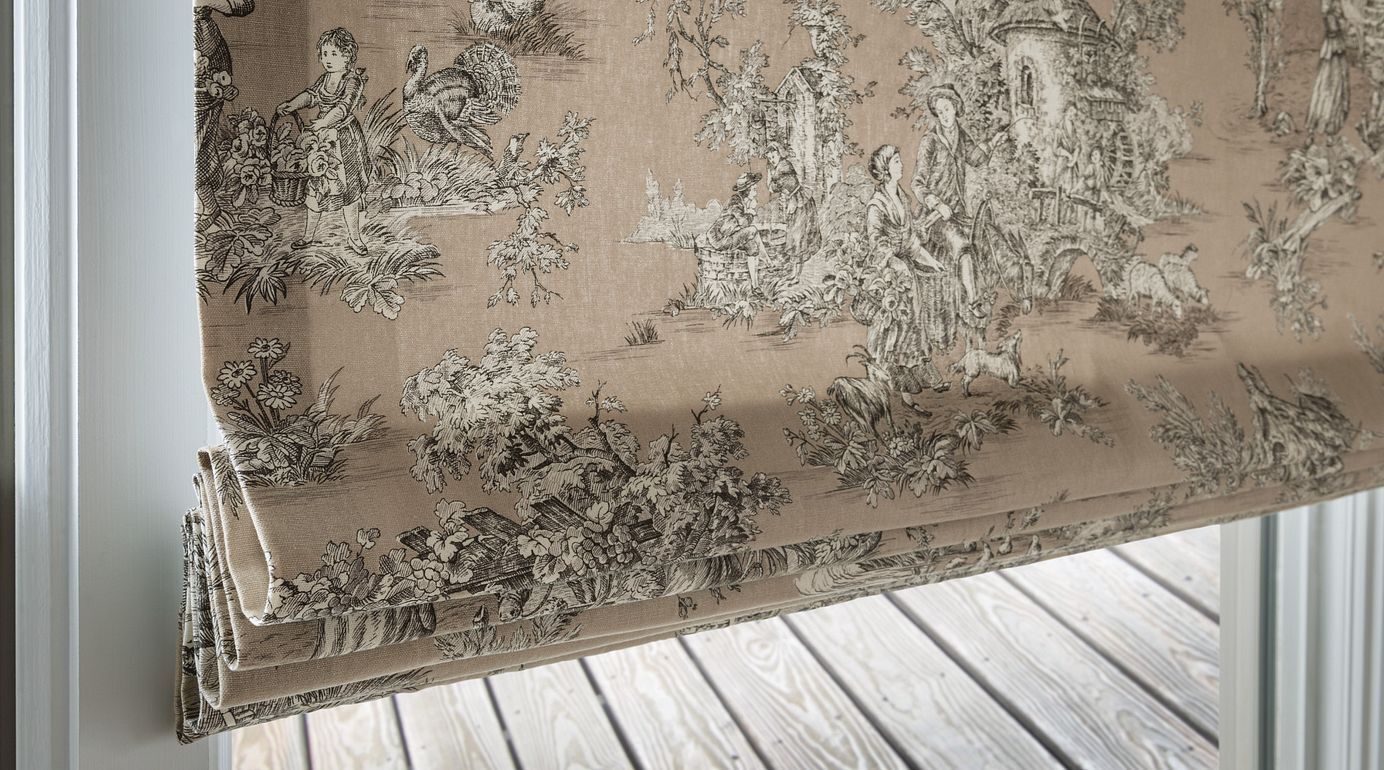 A close up of a roman shade on a window.