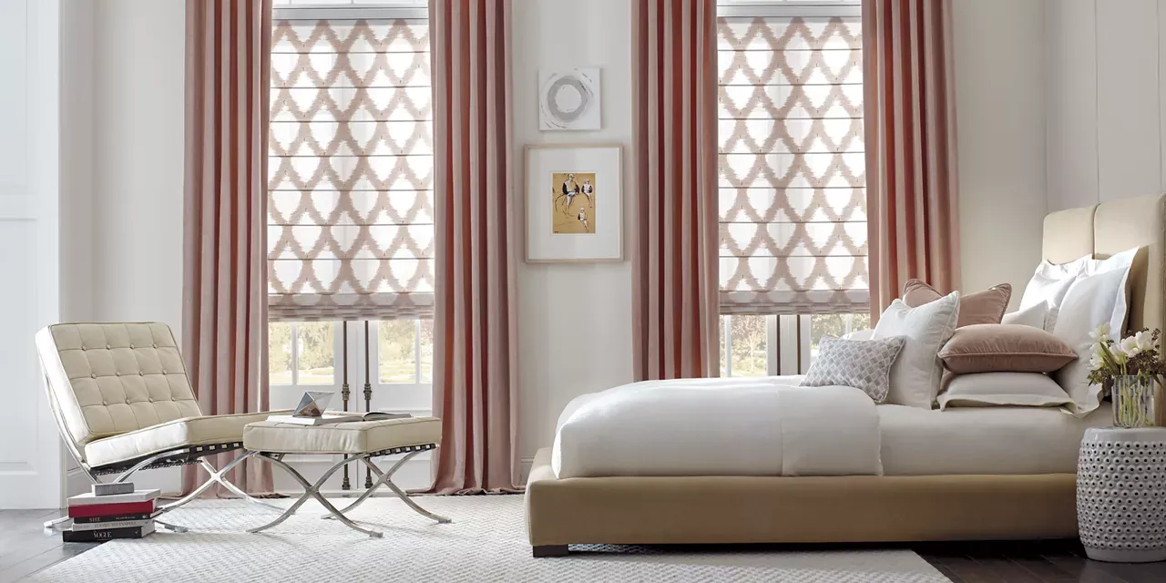 A bedroom with a bed , chair , table and curtains.