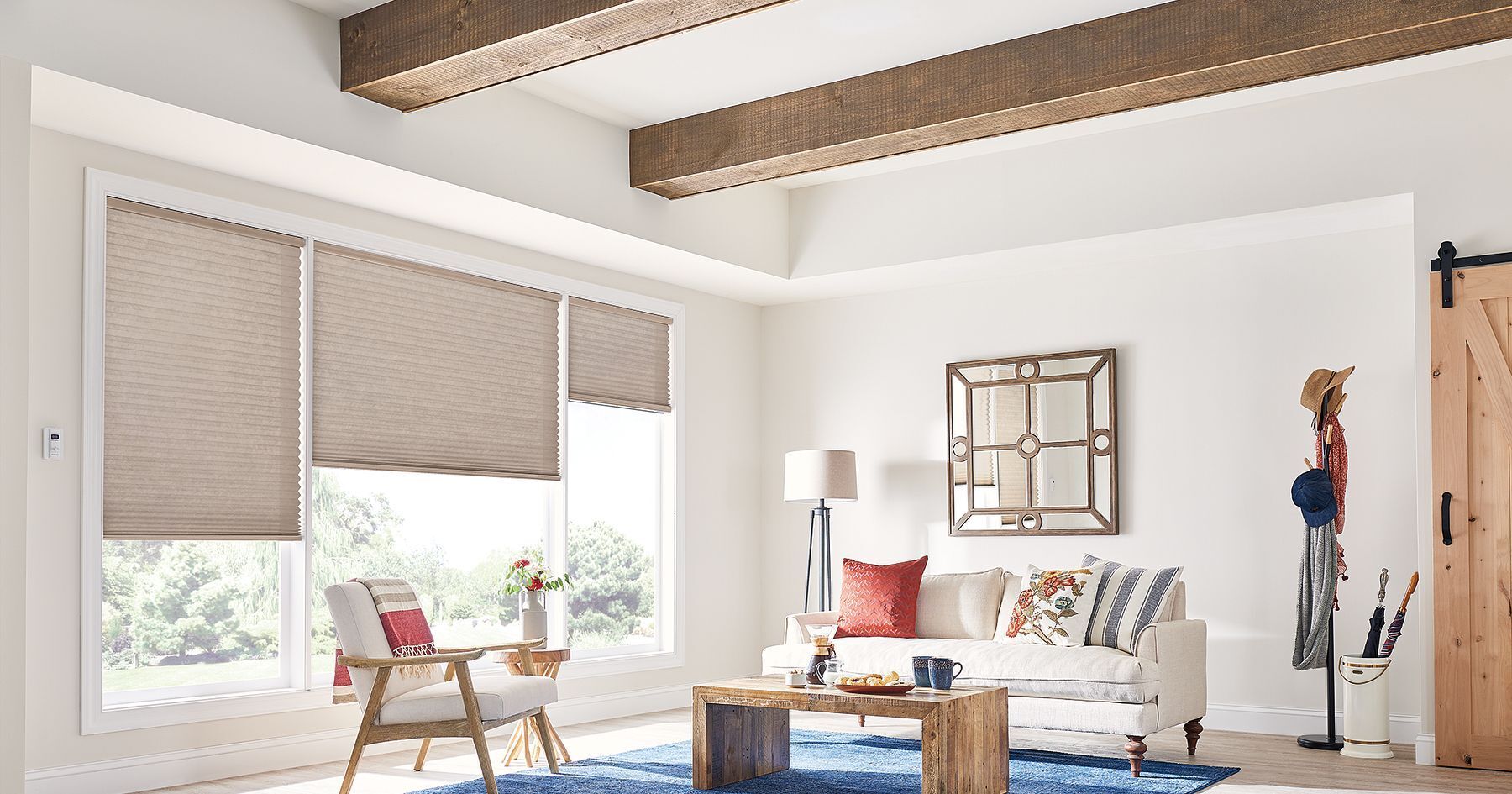 A living room with a couch , chair , table and window.