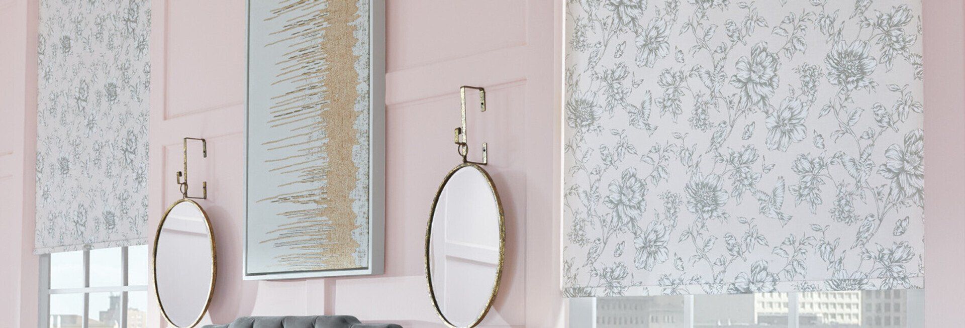 A bathroom with two mirrors , a vanity , and a pink wall.