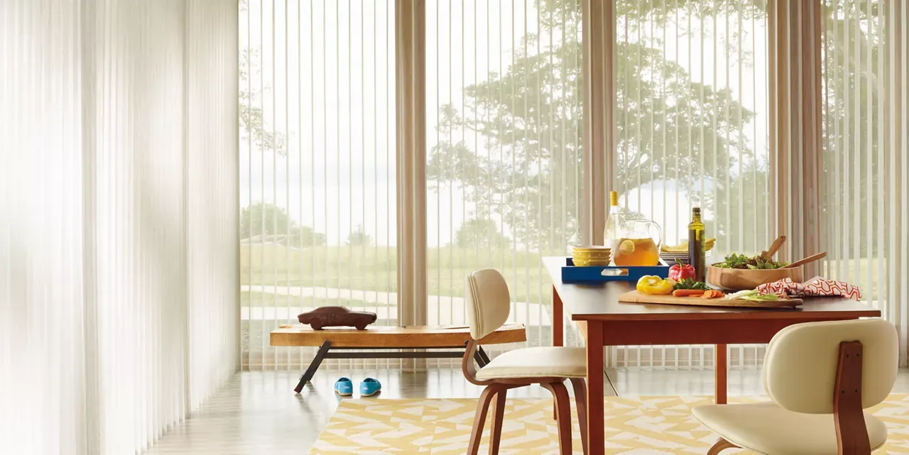 A dining room with a table and chairs and blinds on the windows.