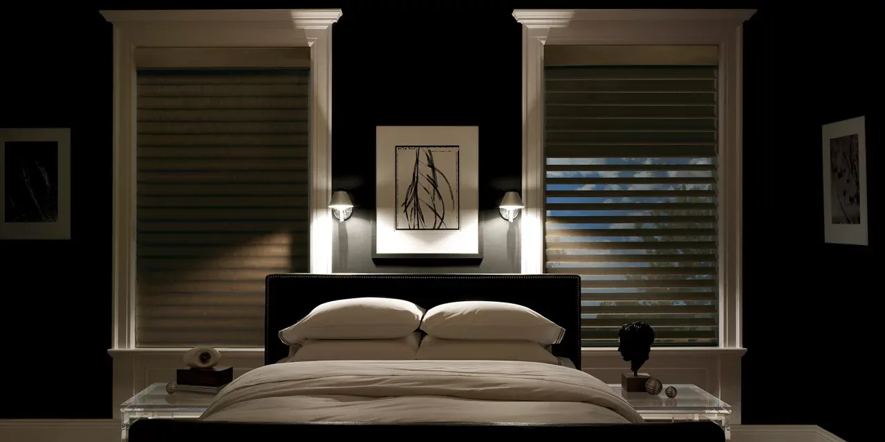 A bedroom with a bed and two windows with blinds