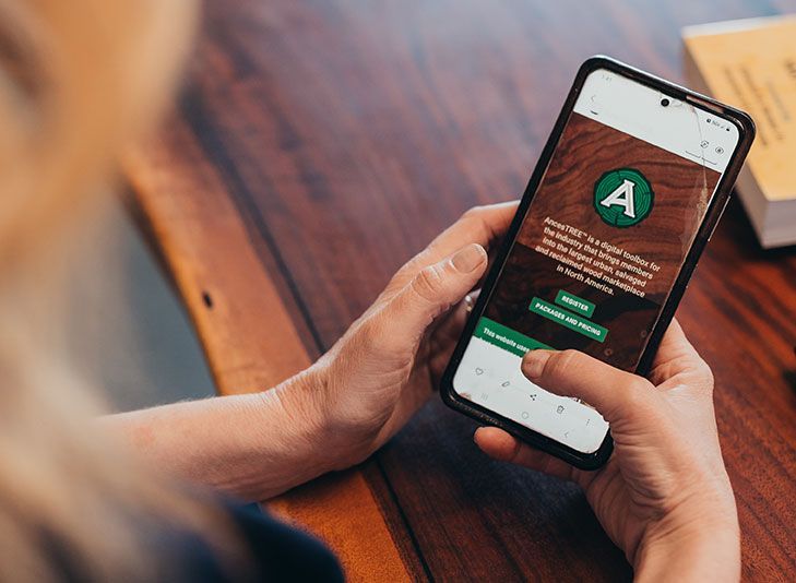 A person is holding a cell phone with the letter a on the screen.