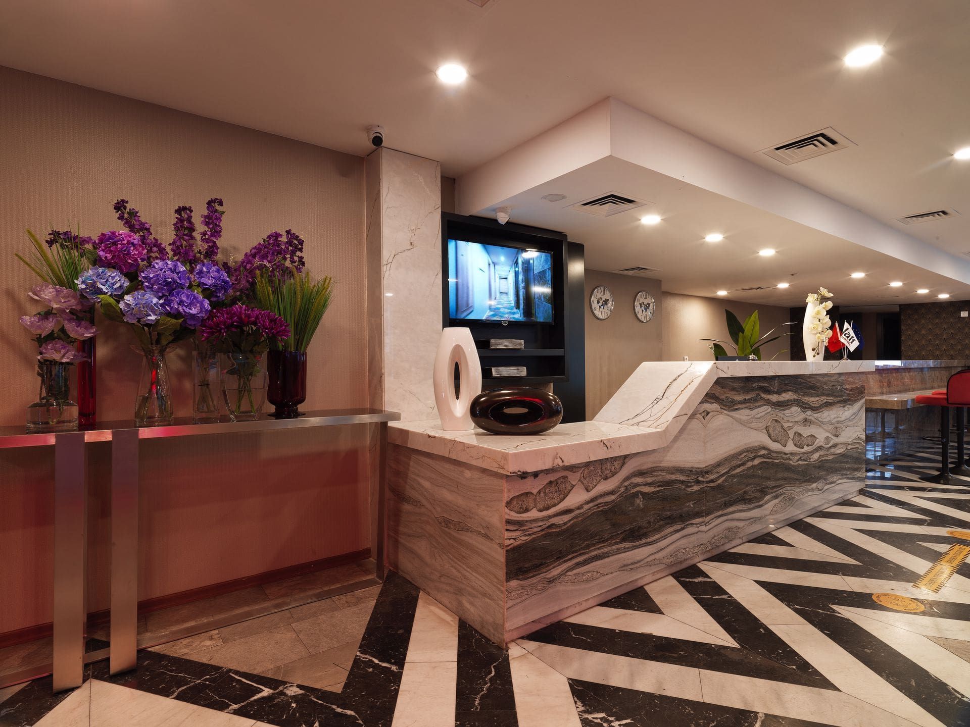A hotel lobby with a marble counter top and a striped floor