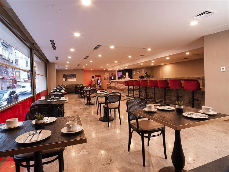 A restaurant with tables and chairs and a bar.