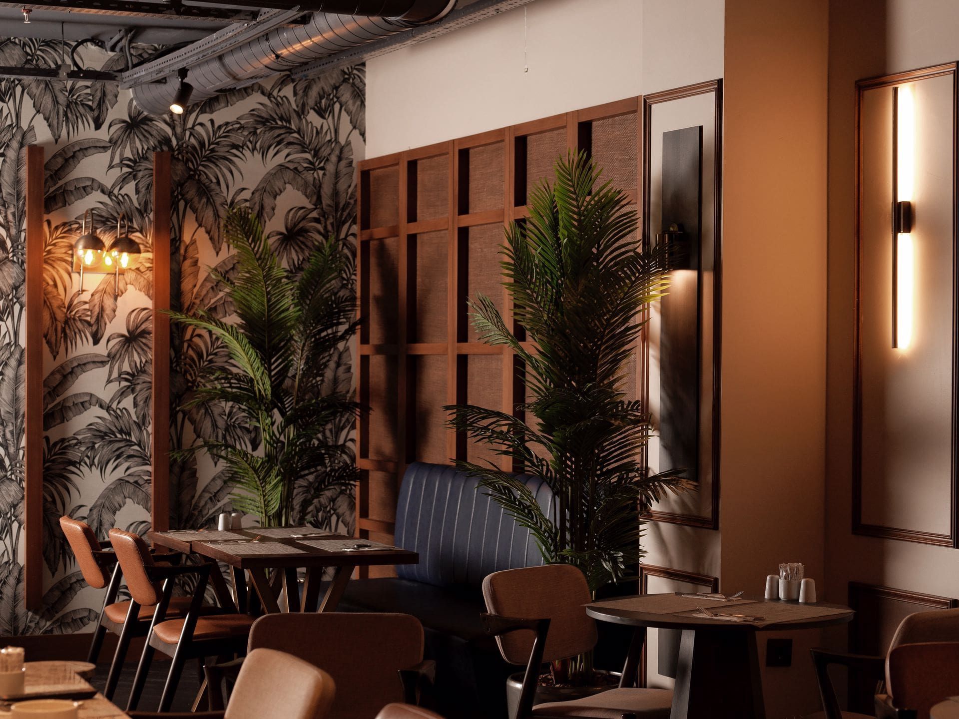 A restaurant with tables and chairs and plants on the wall.
