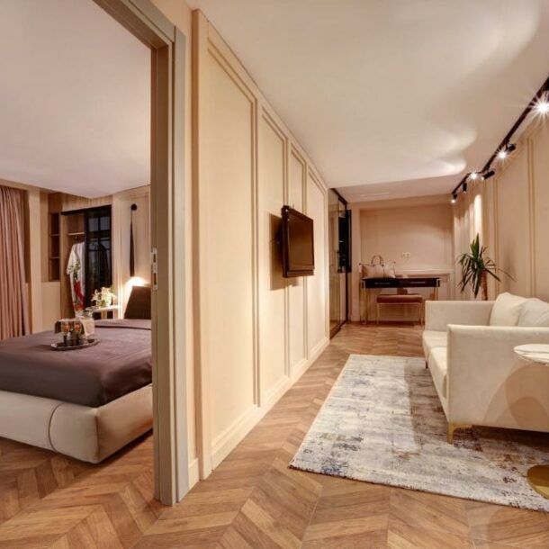 A bedroom with a couch and a television on the wall