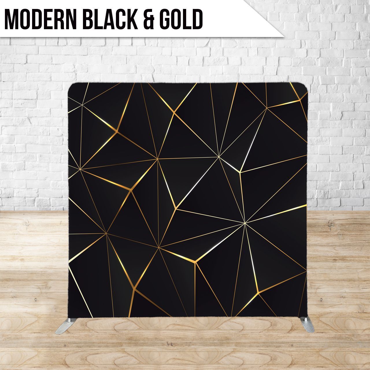 Black and gold geometric backdrop on a stand, set against a brick wall and wooden floor.