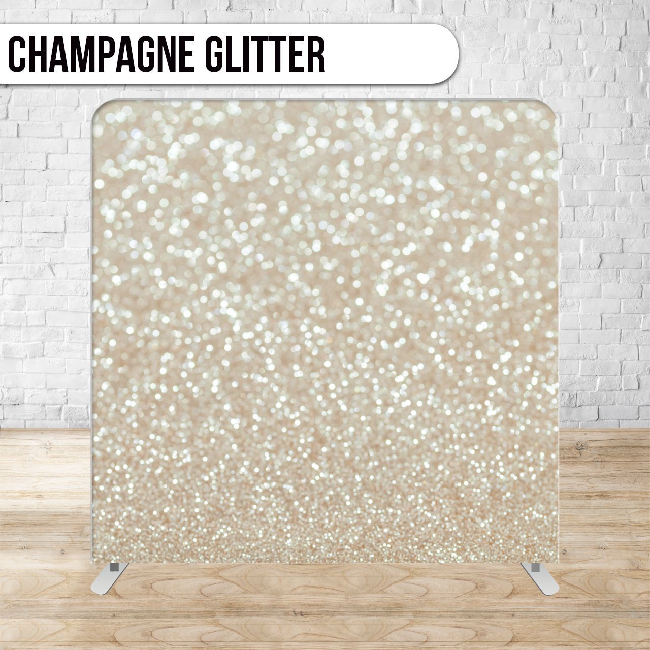 Champagne glitter backdrop set up on a wooden floor in front of a white brick wall.
