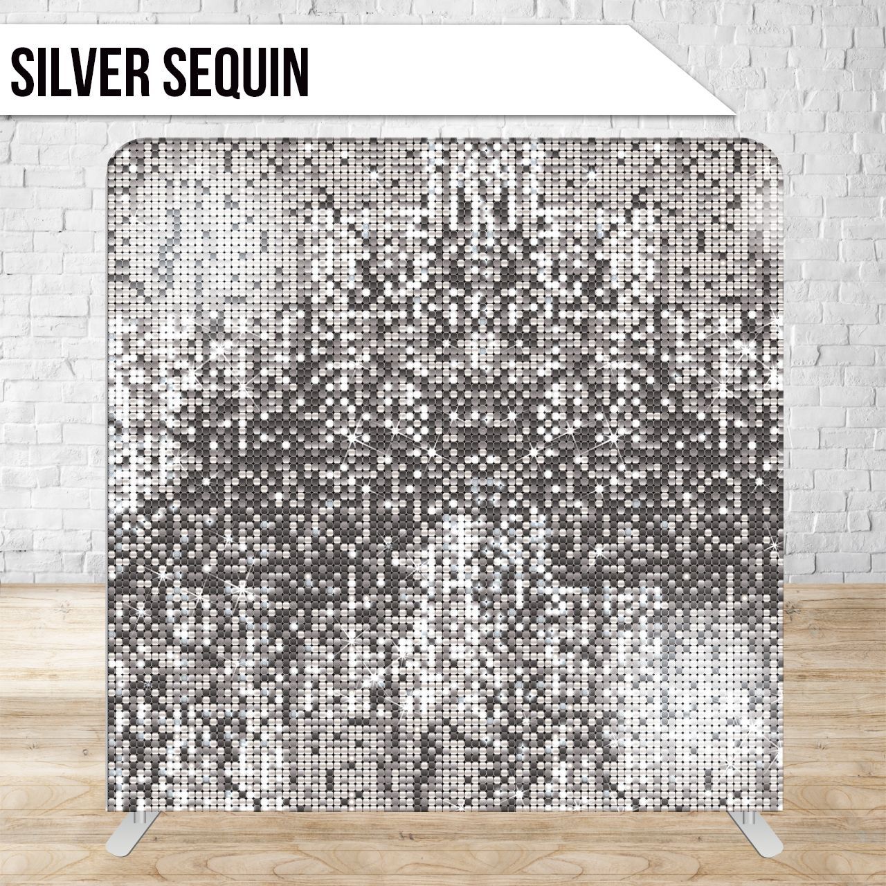 Silver sequin backdrop against a white brick wall and wooden floor.
