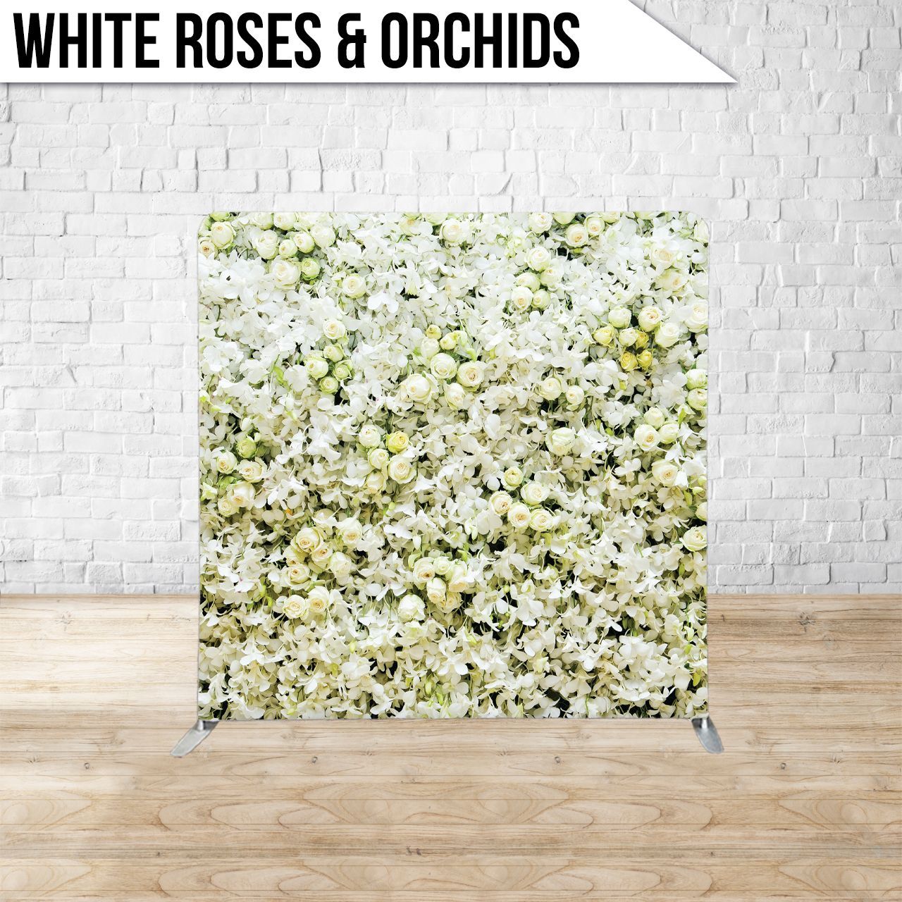 A backdrop featuring white roses and orchids against a brick wall.