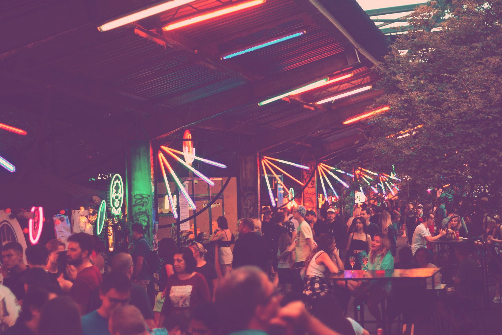 A crowd of people are sitting at tables in a restaurant at night.