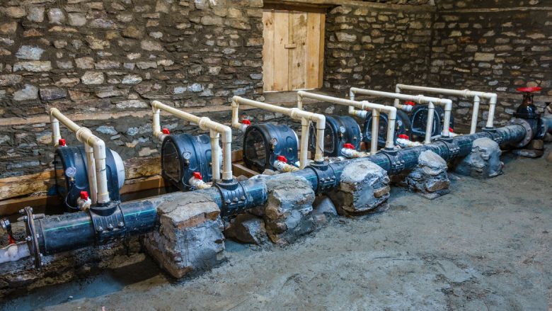 Pipes and pumps in a stone-walled room, likely for water or industrial use.