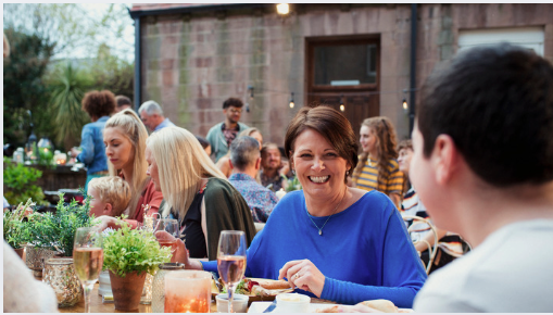 People enjoying a relaxed holiday meal together, showing how to lose weight during the holidays with