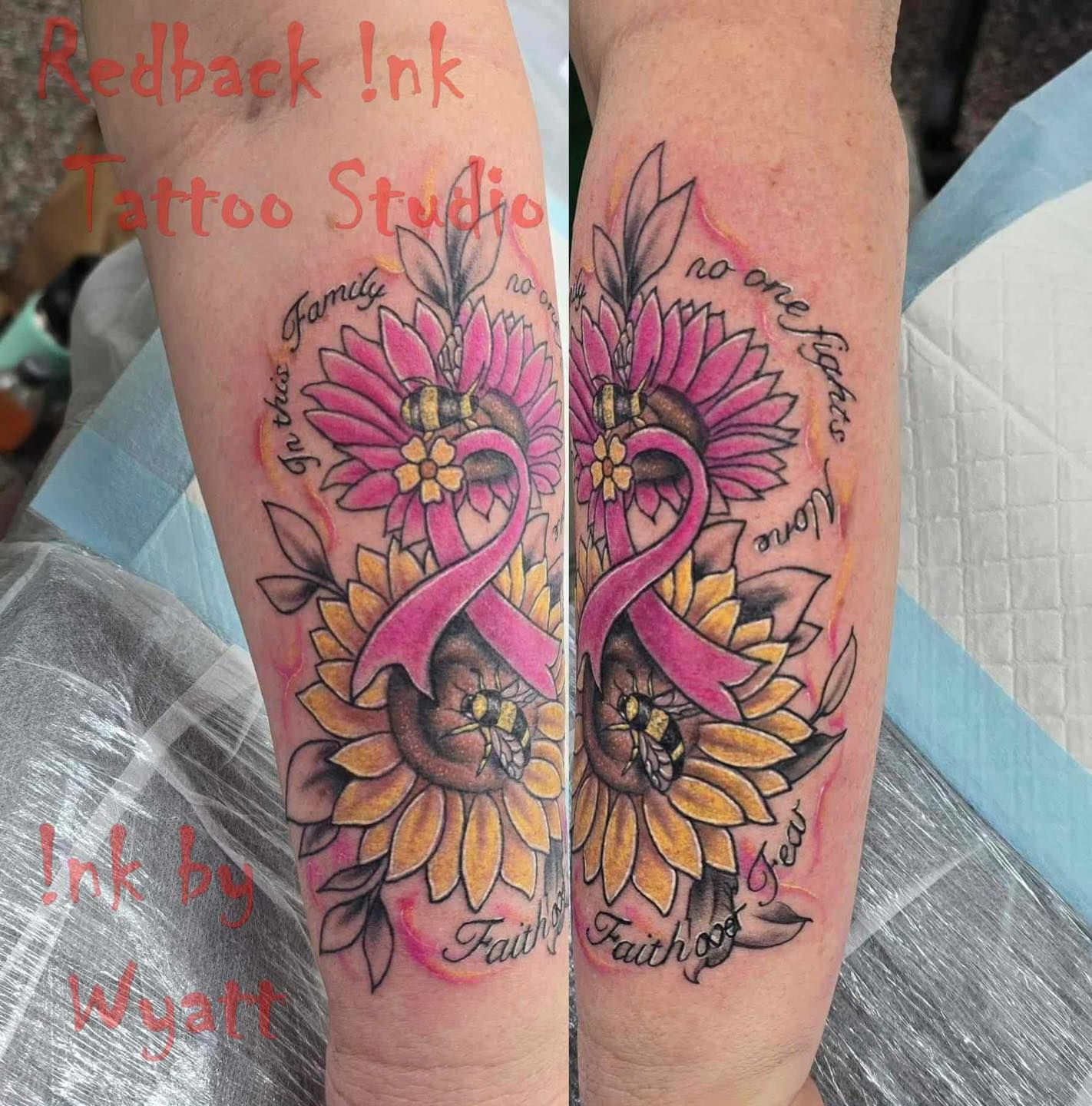 Tattoo of sunflowers, a pink ribbon, and text on an arm. Features are yellow and pink with surrounding green leaves.