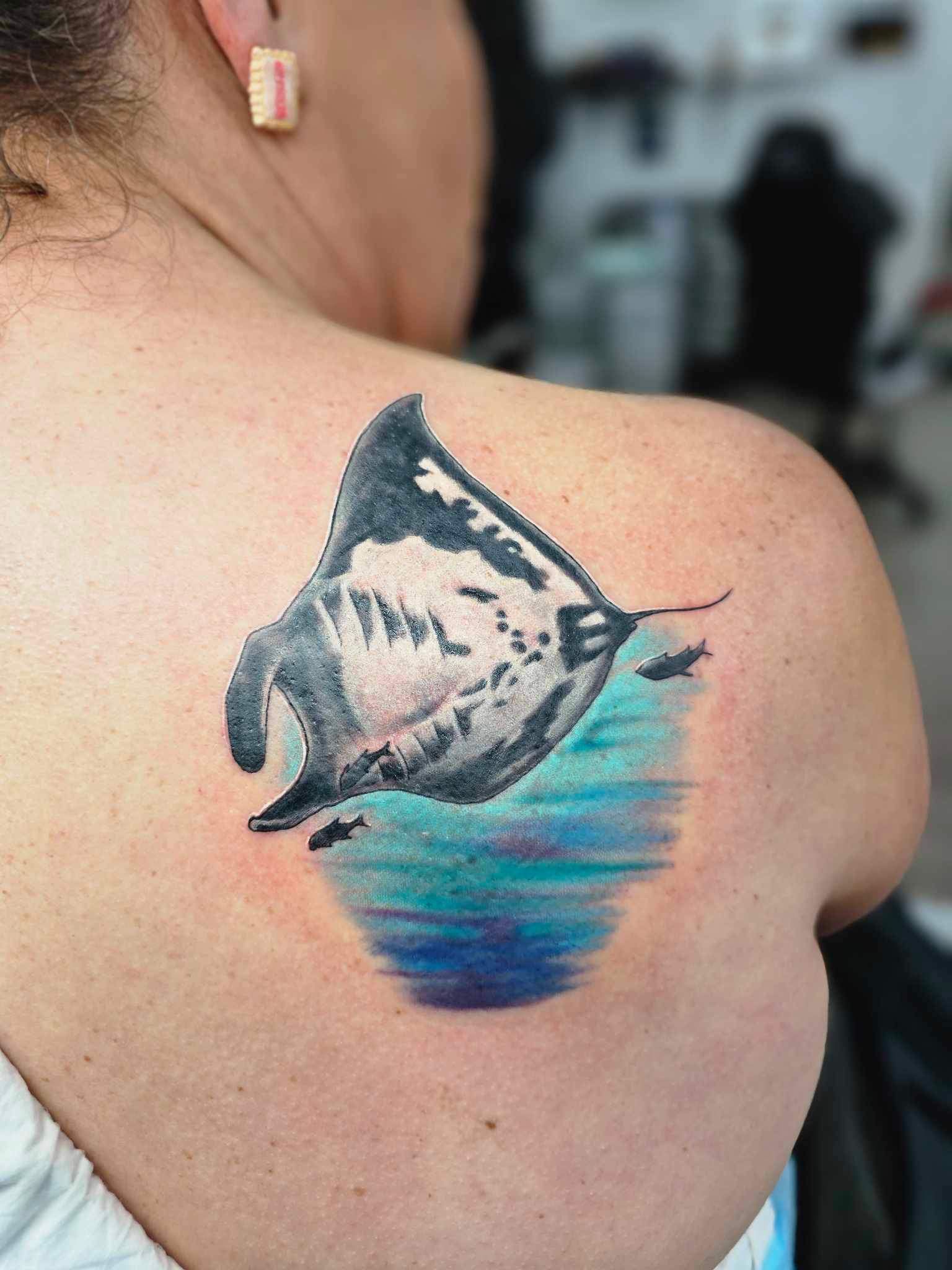 Tattoo of a Manta Ray Swimming in Blue Water on a Person's Shoulder — Redback !nk Tattoo Studio in Kawana, QLD