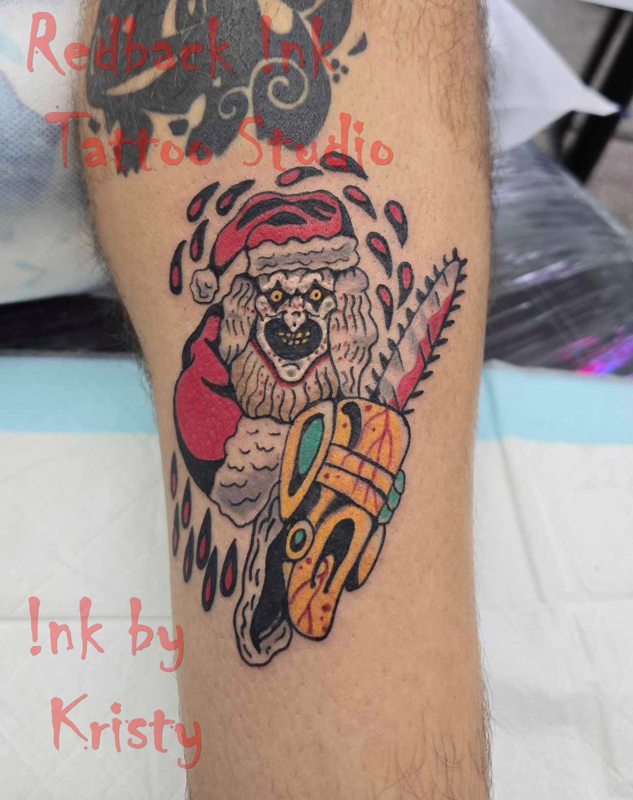 Tattoo of Santa with a chainsaw, bloody tears. Santa is wearing a red hat and suit, with an evil grin — Redback !nk Tattoo Studio in Kawana, QLD