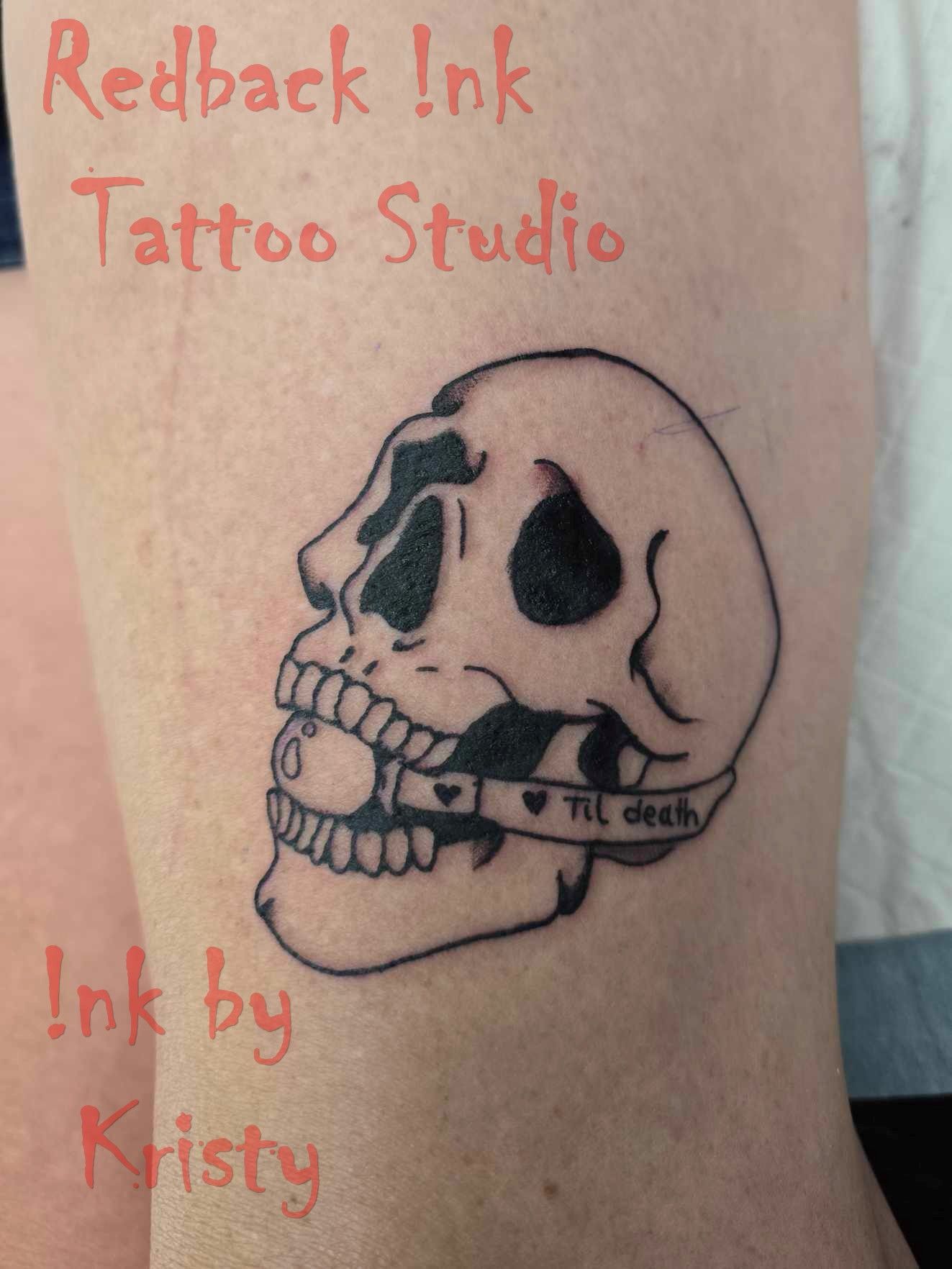 Black skull tattoo with “Til Death” banner on skin — Redback !nk Tattoo Studio in Kawana, QLD