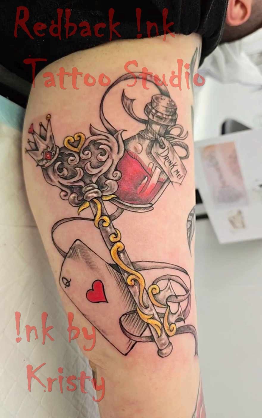 Tattoo on arm: ornate key with potion bottle, Ace of Hearts playing card, and gold accents — Redback !nk Tattoo Studio in Kawana, QLD