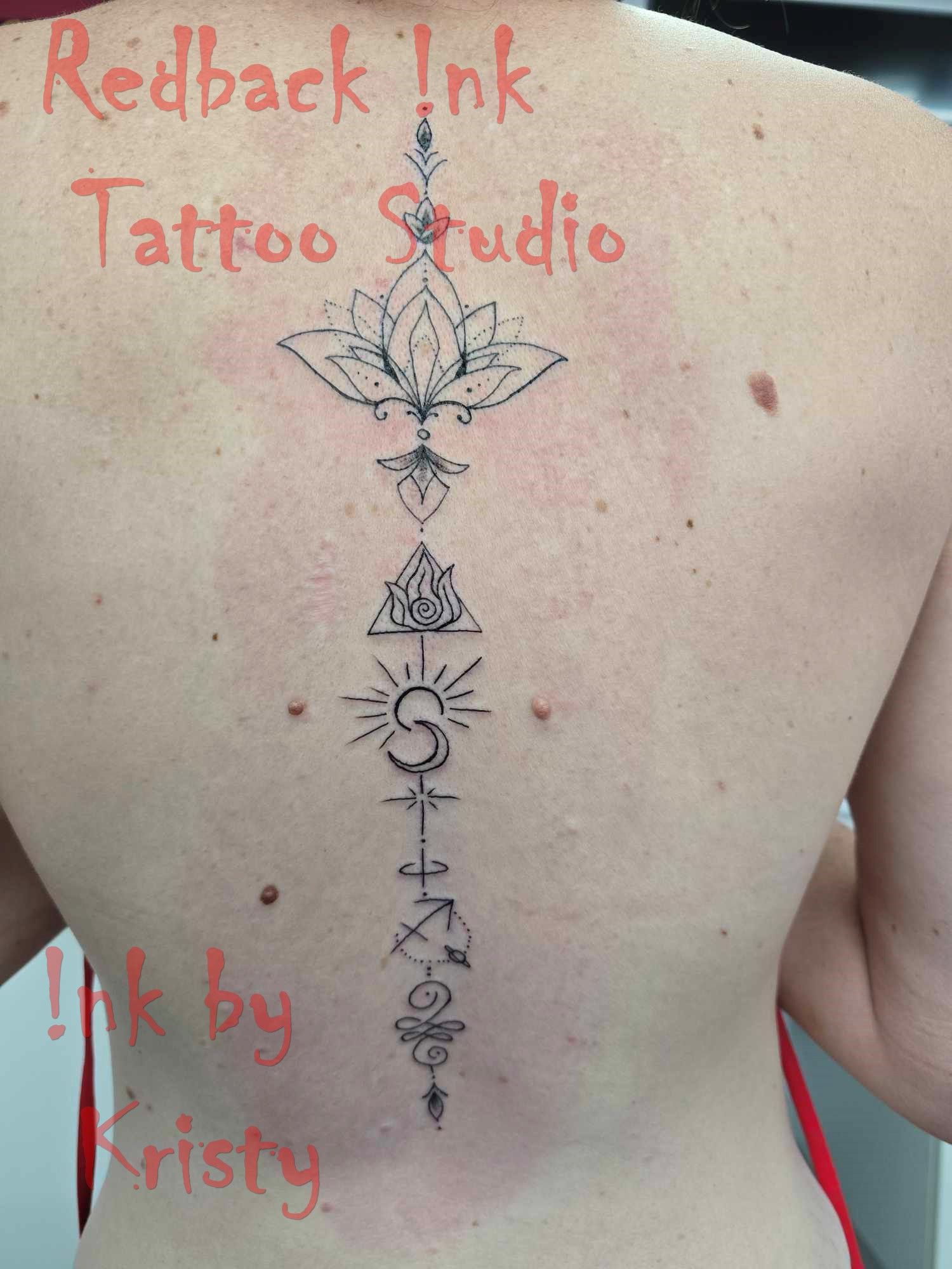 Back tattoo: lotus flower, symbols down spine, Redback Ink Tattoo Studio — Redback !nk Tattoo Studio in Kawana, QLD