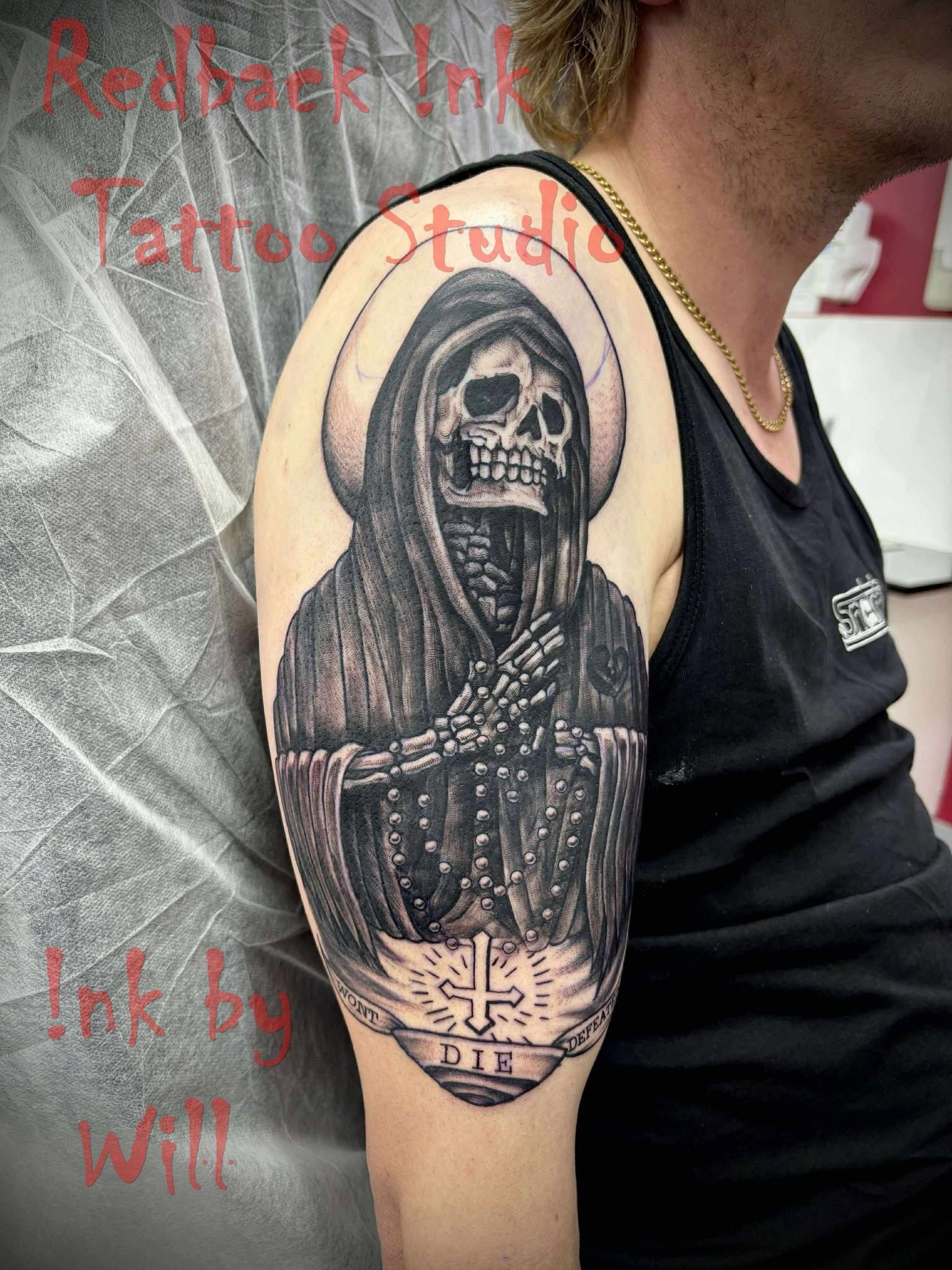 Tattoo of a hooded Grim Reaper skeleton with halo and cross on a man's arm. Black and white.