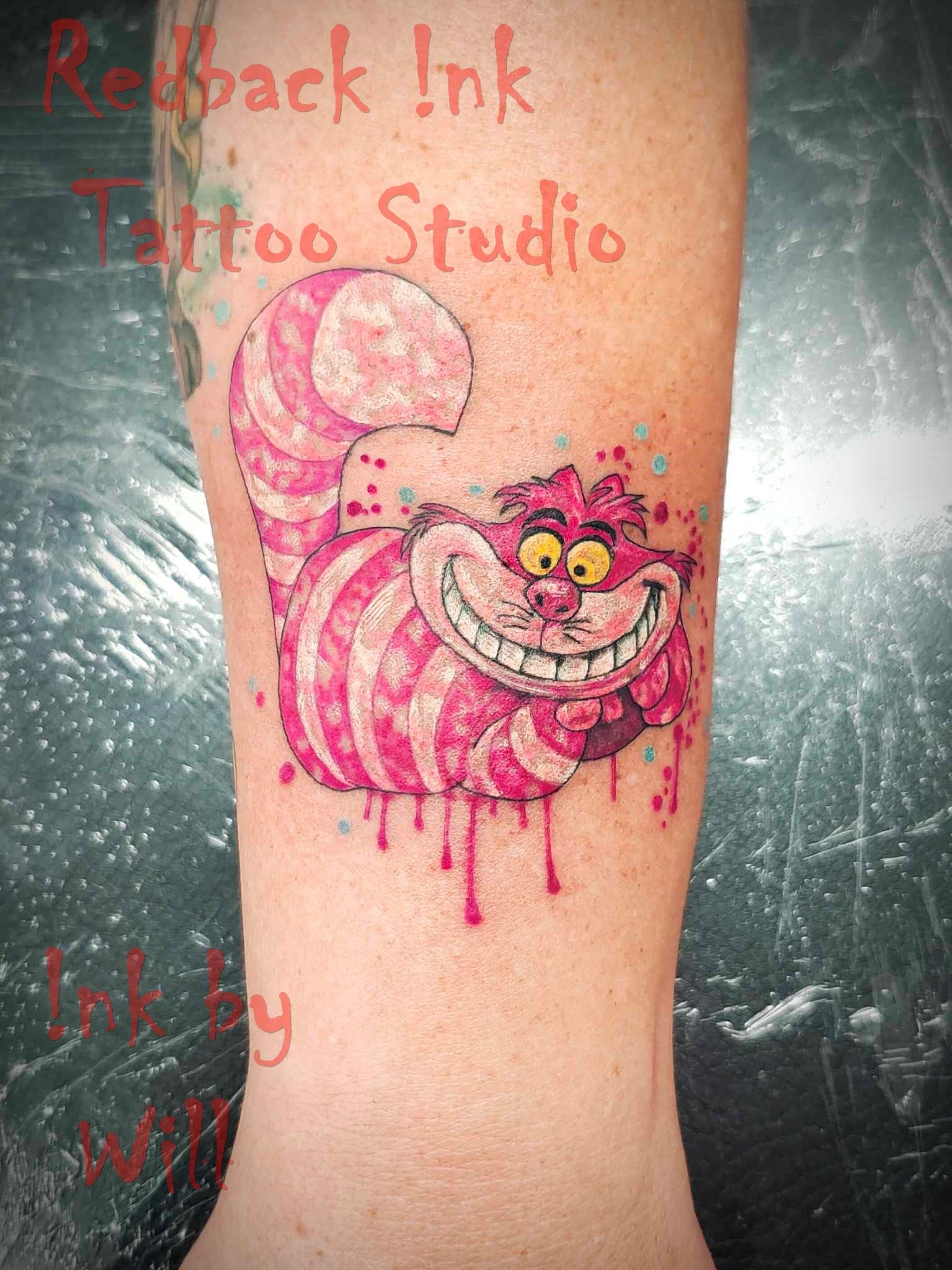 Cheshire Cat tattoo in pink and white, with watercolor effects, on a person's arm.