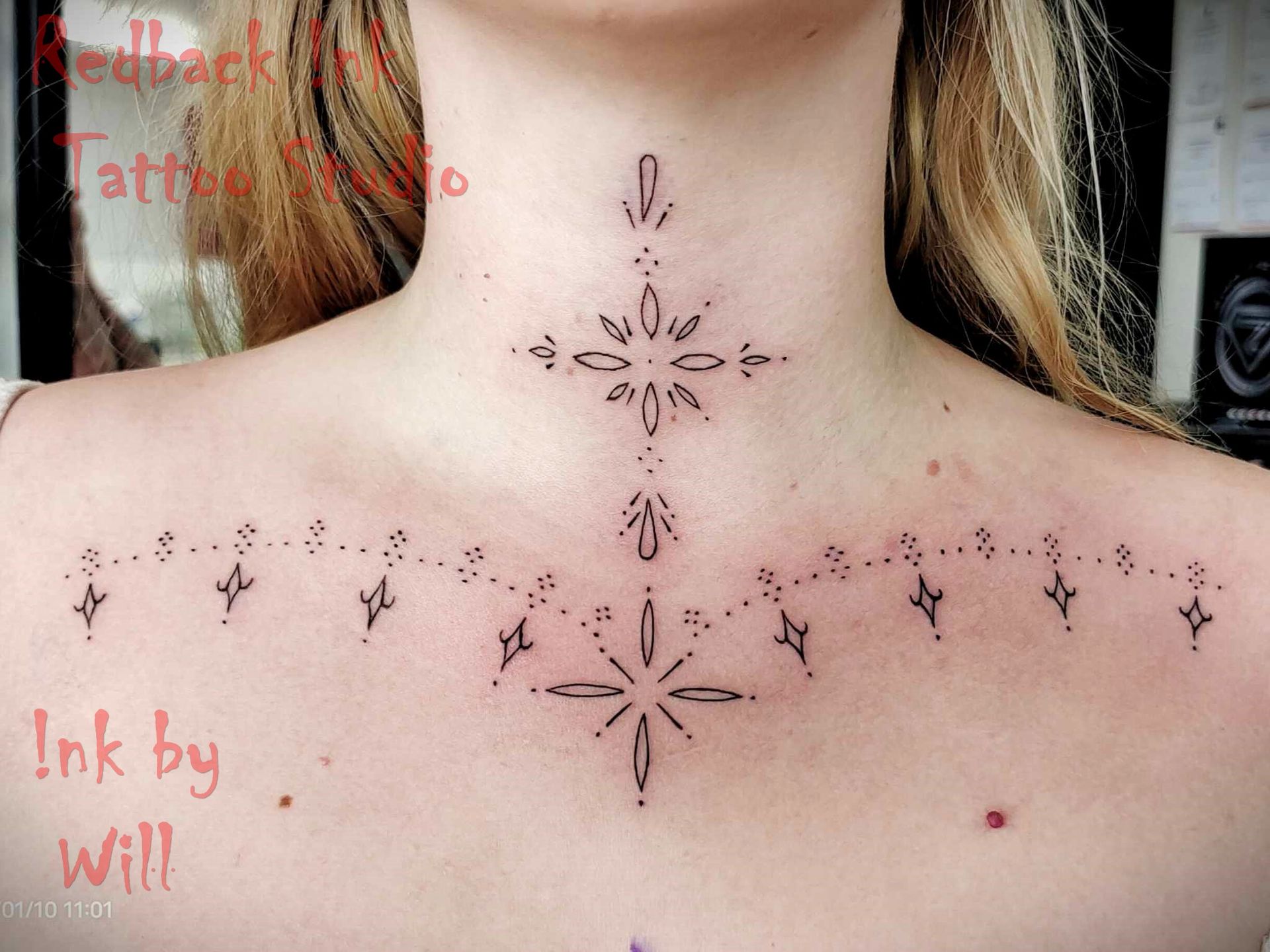 Neck and upper chest tattoo of a starburst and dotted line design.