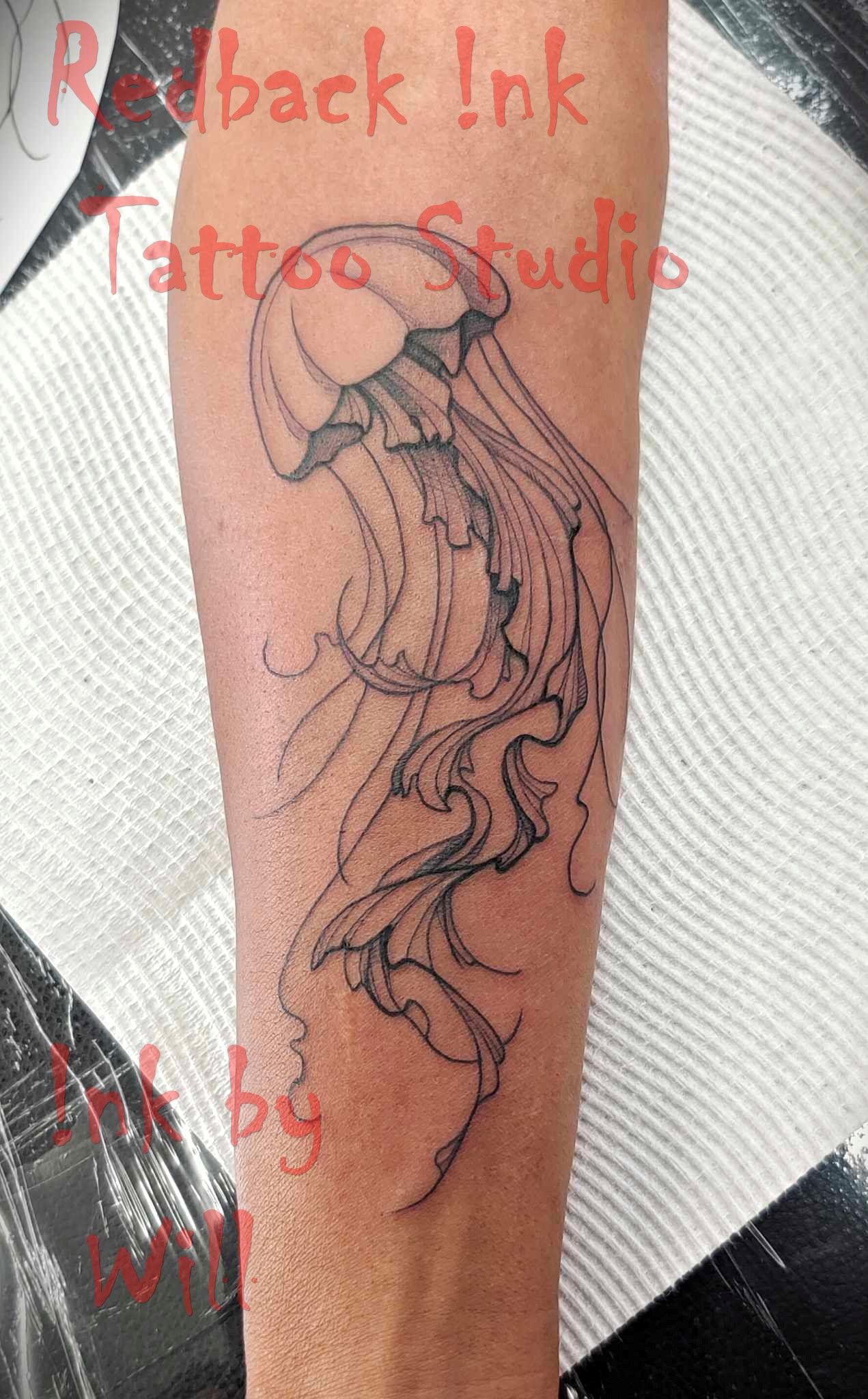 Black jellyfish tattoo on arm.