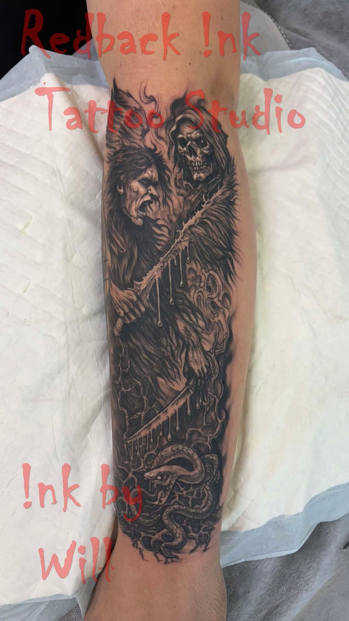 Black tattoo on an arm depicting two figures in a dark, detailed scene.