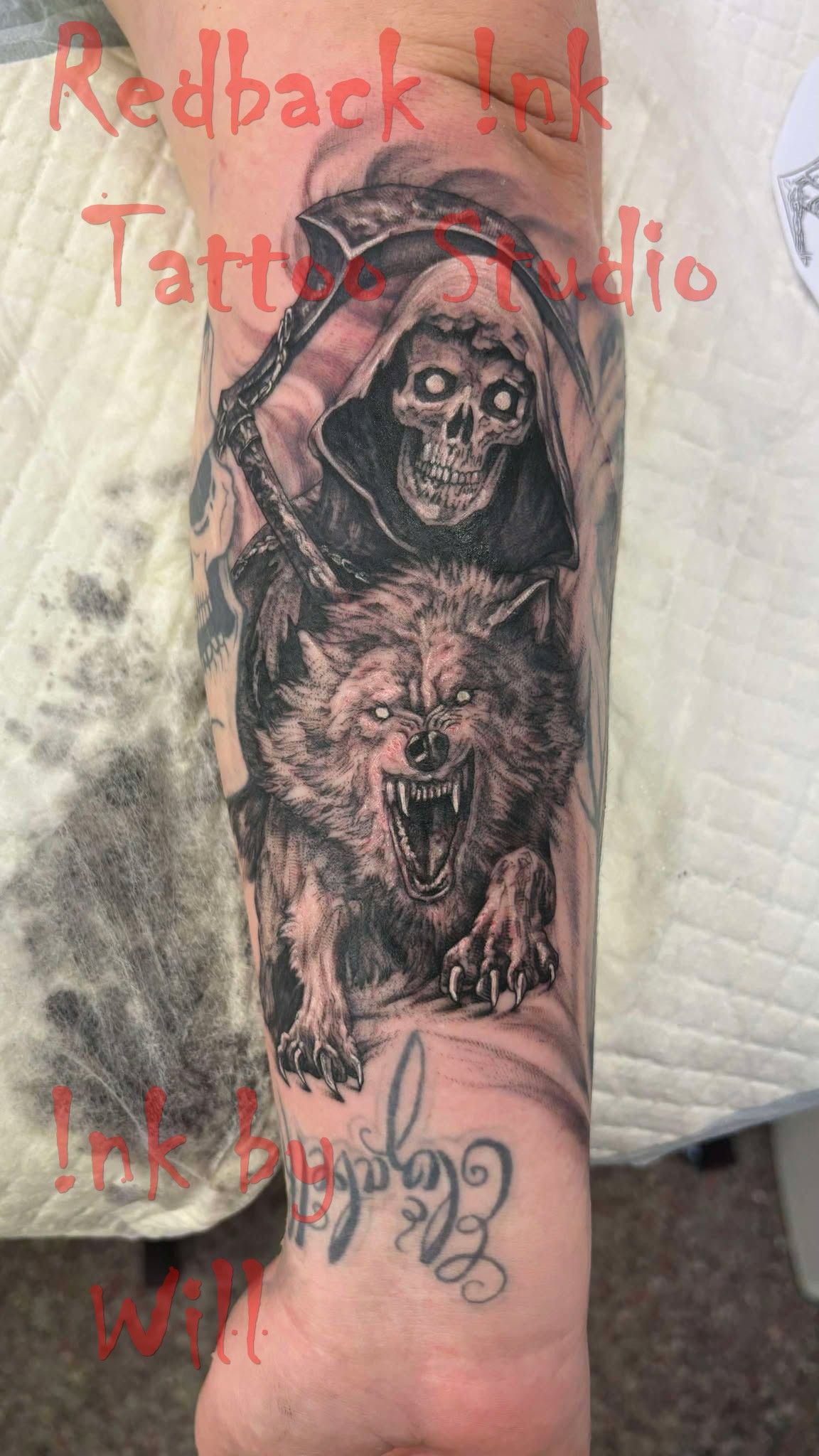 Grim reaper on wolf tattoo. Skull-faced reaper in hood on snarling wolf, black and white. Arm.